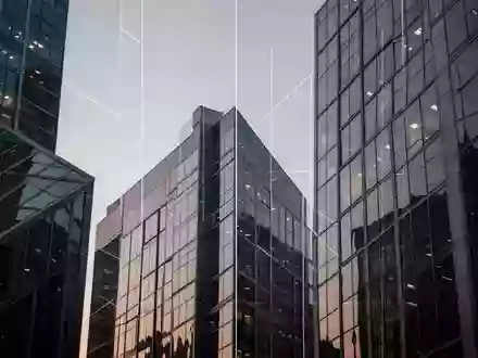 Moderne Glasfassaden eines Bürogebäudes in einem Finanzviertel bei Dämmerung. - Foto: über boerse-global.de