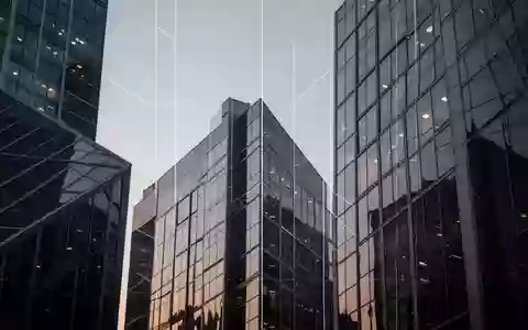 Moderne Glasfassaden eines Bürogebäudes in einem Finanzviertel bei Dämmerung. - Foto: über boerse-global.de