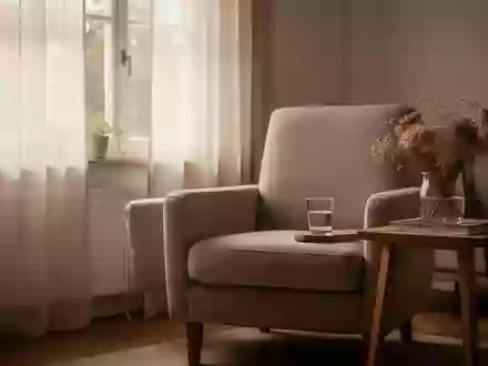 Ein sonnendurchflutetes Wohnzimmer mit einem bequemen Sessel und einem kleinen Beistelltisch vor einem Fenster. - Foto: über boerse-global.de