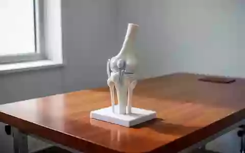 Anatomisches Modell eines menschlichen Kniegelenks auf einem Untersuchungstisch in einem hellen, klinischen Raum. - Foto: über boerse-global.de