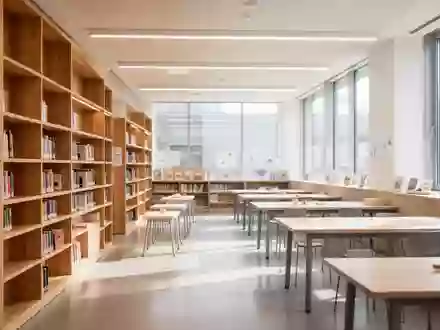 Ein heller, moderner Bibliotheksraum mit leeren Arbeitstischen und Bücherregalen im Hintergrund. - Foto: über boerse-global.de