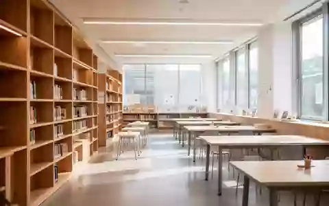 Ein heller, moderner Bibliotheksraum mit leeren Arbeitstischen und Bücherregalen im Hintergrund. - Foto: über boerse-global.de
