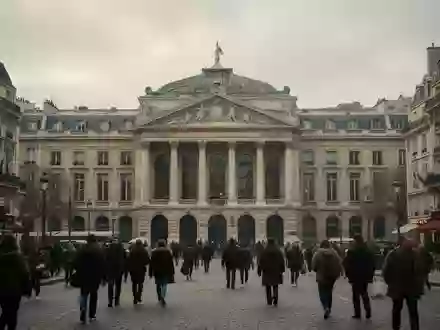 Menschen auf einem belebten Platz in Paris vor historischer Architektur bei bewölktem Himmel. - Foto: über boerse-global.de