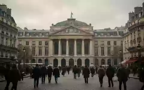 Menschen auf einem belebten Platz in Paris vor historischer Architektur bei bewölktem Himmel. - Foto: über boerse-global.de