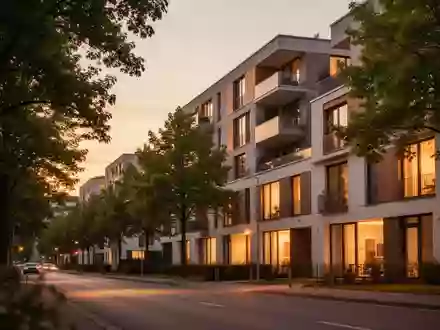 Eine moderne Wohnstraße in Deutschland in der Abenddämmerung mit warm beleuchteten Fenstern eines Wohngebäudes. - Foto: über boerse-global.de