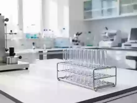 Ein steriler, leerer medizinischer Laborraum mit glänzenden Oberflächen und Reagenzgläsern in einem Gestell. - Foto: über boerse-global.de