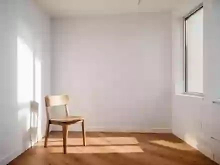 Ein minimalistischer, lichtdurchfluteter Untersuchungsraum mit einem Holzstuhl in einer ruhigen, klinischen Umgebung. - Foto: über boerse-global.de