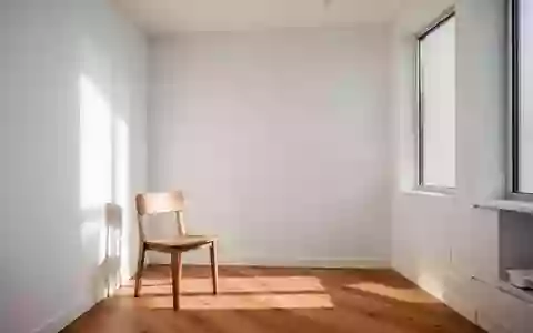 Ein minimalistischer, lichtdurchfluteter Untersuchungsraum mit einem Holzstuhl in einer ruhigen, klinischen Umgebung. - Foto: über boerse-global.de