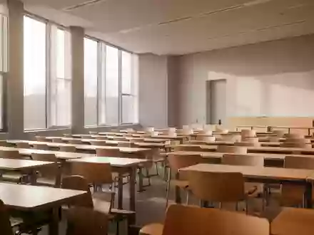 Ein leerer, modern gestalteter Seminarraum einer Universität mit Holztischen und Stühlen in natürlichem Tageslicht. - Foto: über boerse-global.de