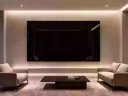 Ein minimalistisch eingerichtetes, modernes Wohnzimmer mit einer leeren, dunklen Wandfläche und indirekter Beleuchtung. - Foto: über boerse-global.de