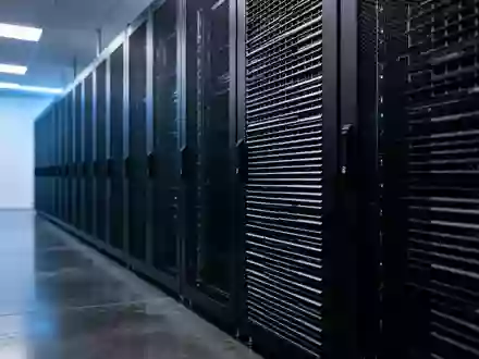 Reihen von leeren, dunklen Server-Racks in einem minimalistischen, blau beleuchteten Serverraum. - Foto: über boerse-global.de