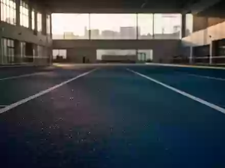 Leere, minimalistische Leichtathletik-Laufbahn in einer modernen Sporthalle bei natürlichem Lichteinfall. - Foto: über boerse-global.de
