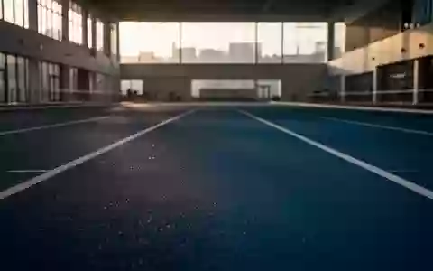 Leere, minimalistische Leichtathletik-Laufbahn in einer modernen Sporthalle bei natürlichem Lichteinfall. - Foto: über boerse-global.de