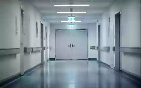 Ein steriler, modern gestalteter Krankenhausflur mit glänzendem Boden und sanfter Beleuchtung ohne Personen. - Foto: über boerse-global.de