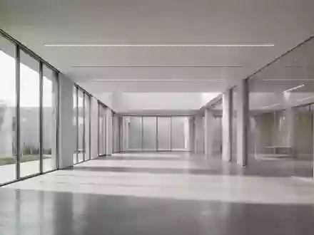 Modernes, minimalistisches Bürointerieur mit klaren Linien und natürlichem Licht, das auf einen polierten Betonboden fällt. - Foto: über boerse-global.de