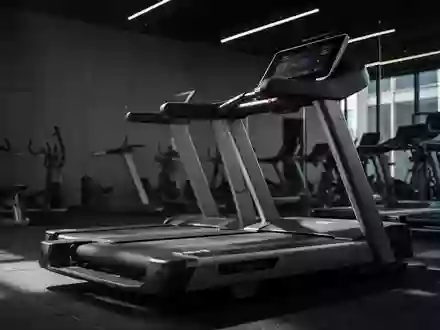 Ein leeres Laufband in einem modernen Fitnessstudio bei gedimmtem Licht. - Foto: über boerse-global.de