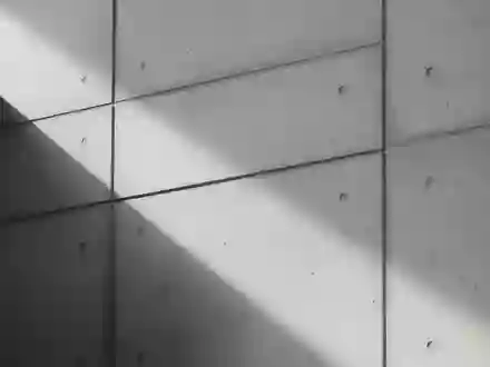 Minimalistische architektonische Detailaufnahme einer Betonwand mit präzisen Schattenwürfen. - Foto: über boerse-global.de