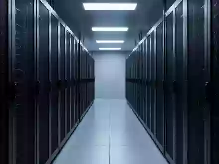 Ein steriler Serverraum mit dunklen, leeren Serverschränken in einer kühlen, blau beleuchteten Industrieumgebung. - Foto: über boerse-global.de