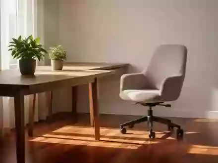 Ein minimalistischer, sonnendurchfluteter Arbeitsplatz mit einer Pflanze und einem ergonomischen Stuhl. - Foto: über boerse-global.de
