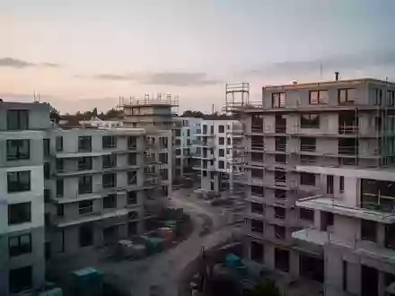 Unfertige Wohngebäude auf einer Baustelle bei Dämmerung, die den aktuellen Wohnungsmangel symbolisieren. - Foto: über boerse-global.de