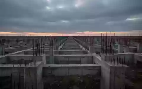 Eine weite, verlassene Baustelle mit Betonfundamenten unter einem bewölkten Himmel, die wirtschaftliche Unsicherheit symbolisiert. - Foto: über boerse-global.de