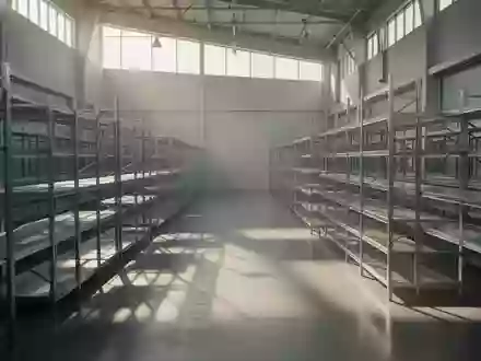 Helle, minimalistische Lagerhalle mit leeren Regalsystemen und einfallendem Tageslicht auf einem Betonboden. - Foto: über boerse-global.de