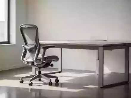 Ein minimalistischer, heller Arbeitsplatz mit einem ergonomischen Bürostuhl und einem Schreibtisch in einem ruhigen Büro. - Foto: über boerse-global.de