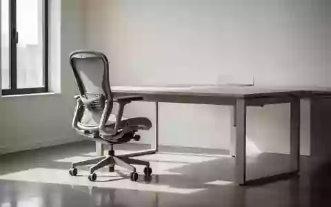 Ein minimalistischer, heller Arbeitsplatz mit einem ergonomischen Bürostuhl und einem Schreibtisch in einem ruhigen Büro. - Foto: über boerse-global.de