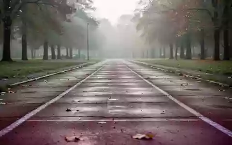 Eine leere, leicht verwitterte Laufbahn in einem herbstlichen Park bei natürlichem Morgenlicht. - Foto: über boerse-global.de