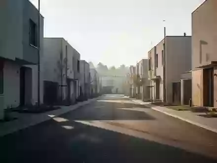 Eine menschenleere Wohnstraße mit moderner Architektur bei ruhigem Morgenlicht. - Foto: über boerse-global.de