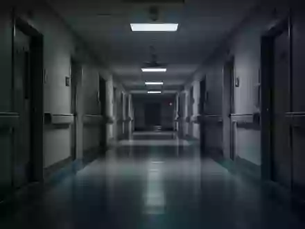 Ein leerer, schwach beleuchteter Krankenhausflur bei Nacht mit langen Schatten und glänzenden Bodenbelägen. - Foto: über boerse-global.de