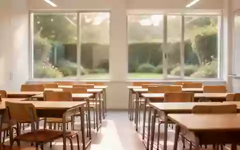 Ein heller, minimalistischer Klassenraum mit leeren Holztischen und Stühlen in natürlichem Tageslicht. - Foto: über boerse-global.de