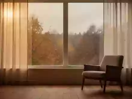 Ein minimalistischer, ruhiger Raum mit herbstlichem Licht durch ein Fenster, das auf eine herbstliche Naturlandschaft blickt. - Foto: über boerse-global.de