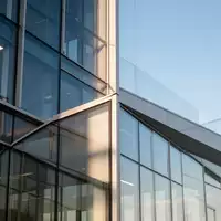 Moderne Glas- und Stahlfassade eines Bürogebäudes bei Tageslicht als Symbol für regulatorische Strukturen. - Foto: über boerse-global.de