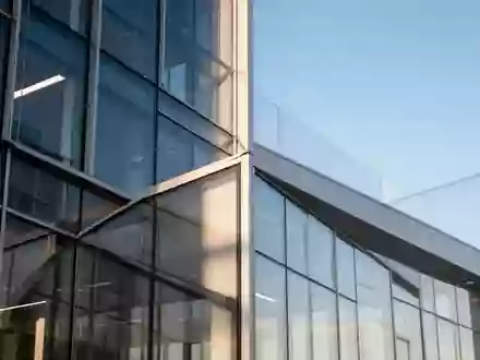 Moderne Glas- und Stahlfassade eines Bürogebäudes bei Tageslicht als Symbol für regulatorische Strukturen. - Foto: über boerse-global.de