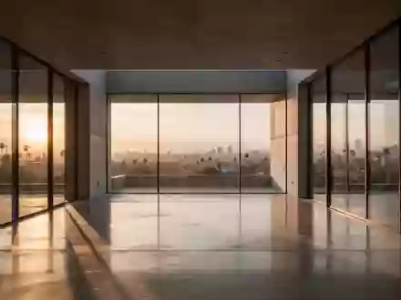 Ein minimalistischer, moderner Innenraum mit polierten Betonböden und großen Glasfronten, die das Licht des Sonnenuntergangs reflektieren. - Foto: über boerse-global.de