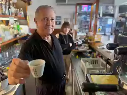 Orlando Paldino zeigt stolz eine Tasse Espresso für 70 Cent. Im Hintergrund steht seine Frau Rosina Furiati. - Foto: Christoph Sator/dpa