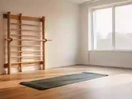 Ein heller, minimalistischer Physiotherapieraum mit einer Sprossenwand aus Holz und einer ausgelegten Trainingsmatte. - Foto: über boerse-global.de