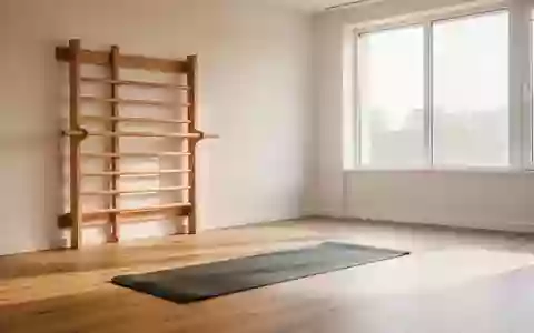 Ein heller, minimalistischer Physiotherapieraum mit einer Sprossenwand aus Holz und einer ausgelegten Trainingsmatte. - Foto: über boerse-global.de