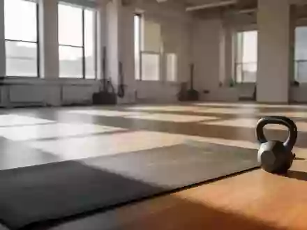 Ein minimalistisch eingerichteter Fitnessraum mit einfallendem Tageslicht und Sportgeräten auf einem Holzboden. - Foto: über boerse-global.de