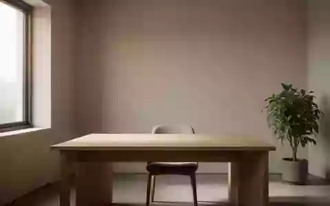 Ein minimalistischer, heller Arbeitsplatz mit einem leeren Holztisch und einer Pflanze in einem ruhigen, aufgeräumten Raum. - Foto: über boerse-global.de