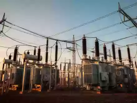 Hochspannungstransformatoren und Stromleitungen einer industriellen Umspannstation im goldenen Licht. - Foto: über boerse-global.de