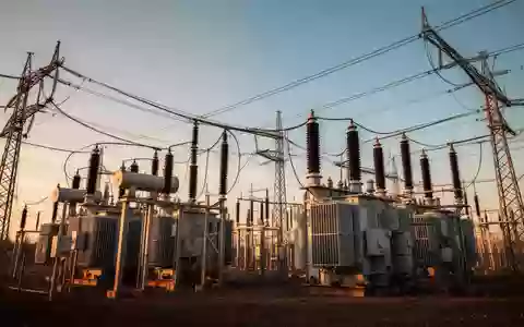 Hochspannungstransformatoren und Stromleitungen einer industriellen Umspannstation im goldenen Licht. - Foto: über boerse-global.de