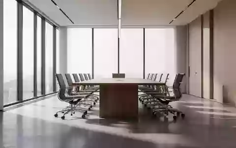 Ein moderner, leerer Konferenzraum mit einem langen Holztisch und natürlichem Lichteinfall durch große Fenster. - Foto: über boerse-global.de
