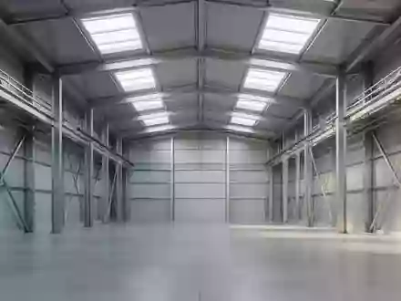 Eine weitläufige, leere Industriehalle mit Stahlträgern und Betonboden bei natürlichem Lichteinfall. - Foto: über boerse-global.de