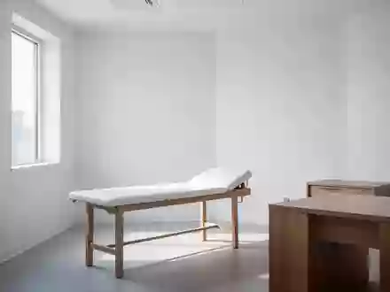 Ein minimalistischer Behandlungsraum in einer Arztpraxis mit einem leeren Untersuchungstisch und weißem Interieur. - Foto: über boerse-global.de