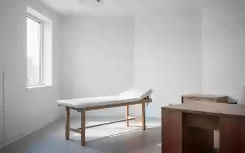 Ein minimalistischer Behandlungsraum in einer Arztpraxis mit einem leeren Untersuchungstisch und weißem Interieur. - Foto: über boerse-global.de