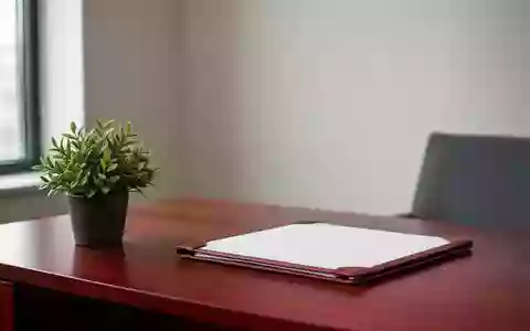 Ein minimalistisch eingerichteter Schreibtisch in einem hellen Büro mit einer Pflanze und einer leeren Dokumentenmappe. - Foto: über boerse-global.de
