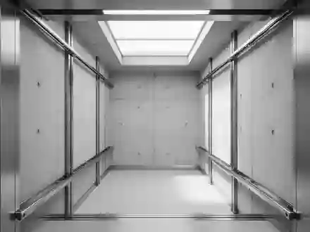 Ein minimalistischer Blick in einen leeren Aufzugsschacht mit Stahlschienen und Betonwänden. - Foto: über boerse-global.de