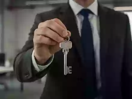 Eine Person in Business-Kleidung hält einen physischen Schlüssel in einem modernen Büro als Symbol für Sicherheit oder Pfand. - Foto: über boerse-global.de